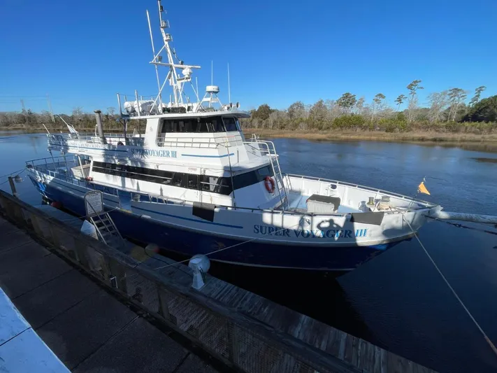 Super Voyager III Yacht Photos Pics Swiftships 1972 commercial passenger vessel docked by a riverbank under clear blue skies.