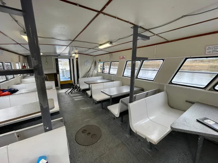 Super Voyager III Yacht Photos Pics Interior of a 1972 Swiftships commercial passenger vessel with seating and windows.