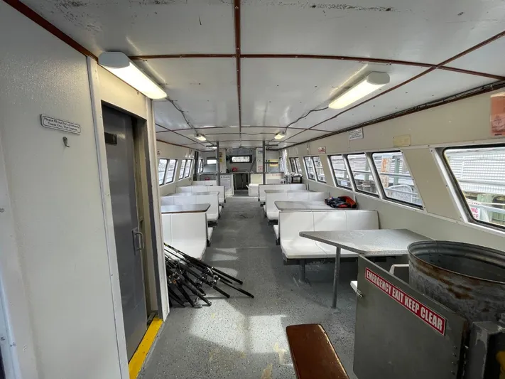 Super Voyager III Yacht Photos Pics Interior of a 1972 Swiftships commercial passenger vessel with white seating and large windows.