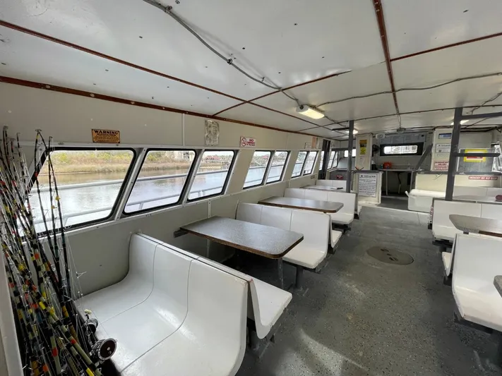 Super Voyager III Yacht Photos Pics 1972 Swiftships commercial passenger boat interior with seating and fishing rods.