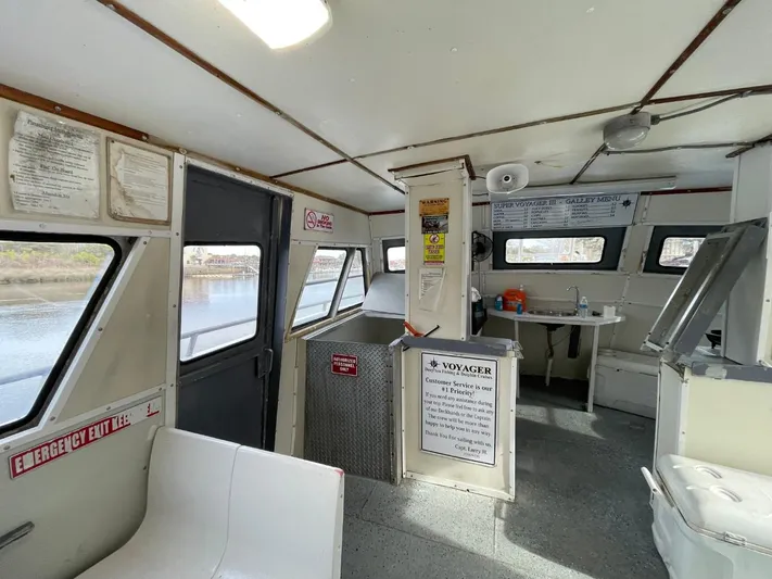 Super Voyager III Yacht Photos Pics Interior of a 1972 Swiftships Commercial Passenger boat, featuring seating and safety notices.