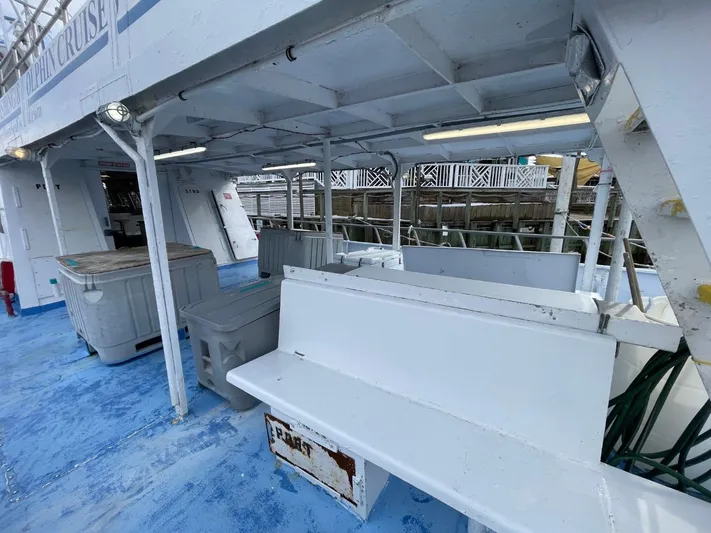 Super Voyager III Yacht Photos Pics 1972 Swiftships Commercial Passenger boat interior with white benches and blue flooring.