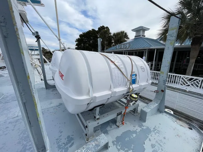 Super Voyager III Yacht Photos Pics Life raft on 1972 Swiftships Commercial Passenger vessel deck, near waterfront building.