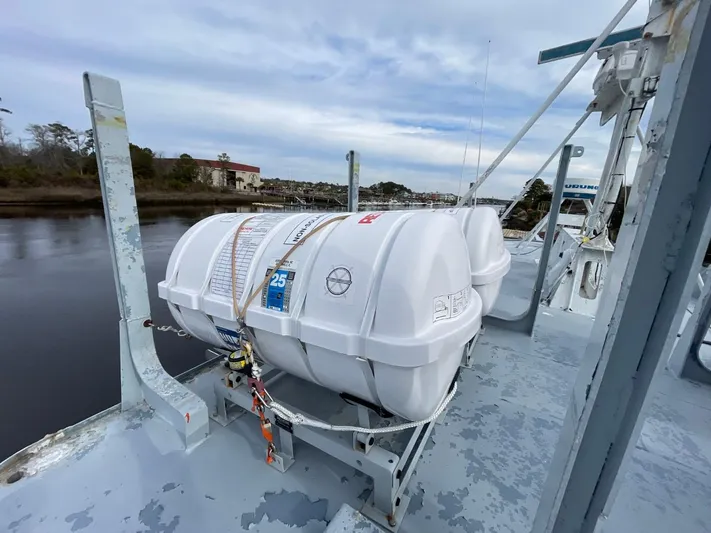 Super Voyager III Yacht Photos Pics 1972 Swiftships Commercial Passenger vessel with life rafts on deck, docked by a calm river.
