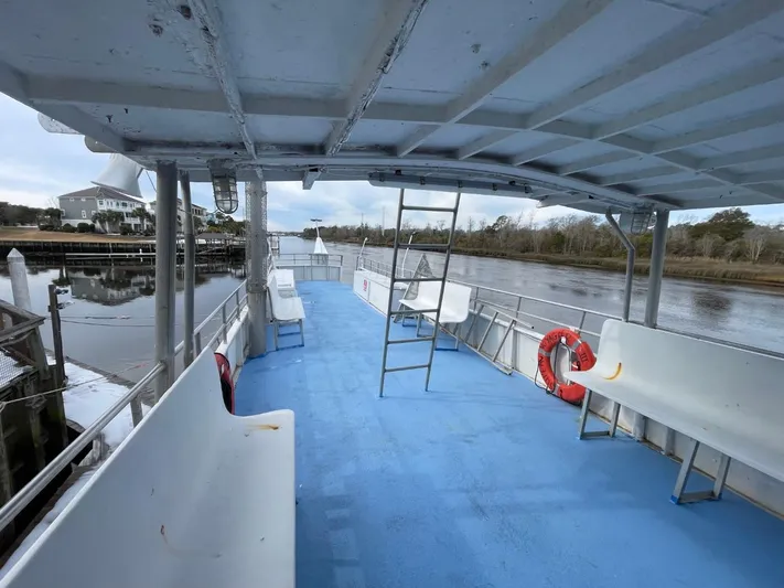 Super Voyager III Yacht Photos Pics 1972 Swiftships Commercial Passenger boat with blue deck, white benches, and life preserver on a river.