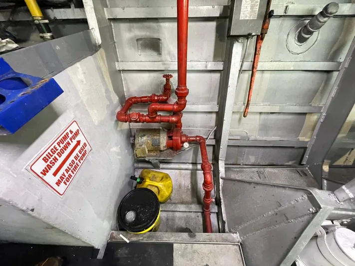 Super Voyager III Yacht Photos Pics Engine room of 1972 Swiftships Commercial Passenger vessel with red pipes and safety sign.