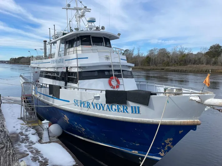 Super Voyager III Yacht Photos Pics Swiftships 1972 Commercial Passenger boat "Super Voyager III" docked by a calm riverbank.