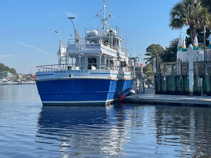 Super Voyager III Yacht Photos Pics 1972 Swiftships Commercial Passenger boat docked, named "Super Voyager III," with blue hull and white upper structure.