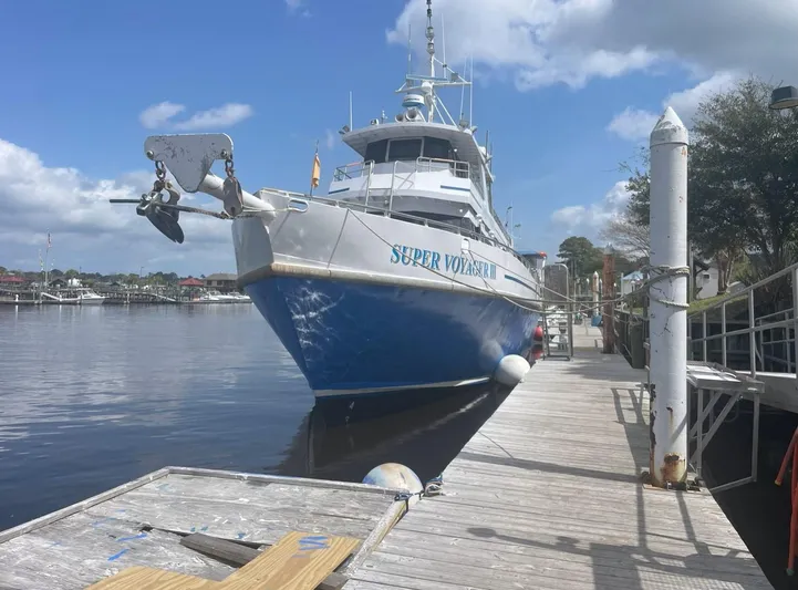 Super Voyager III Yacht Photos Pics Swiftships 1972 commercial passenger vessel docked at a marina under a partly cloudy sky.