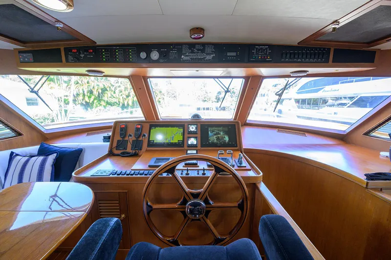 Bandol Yacht Photos Pics Interior helm of 2006 Marlow 78E yacht with navigation equipment and wooden steering wheel.