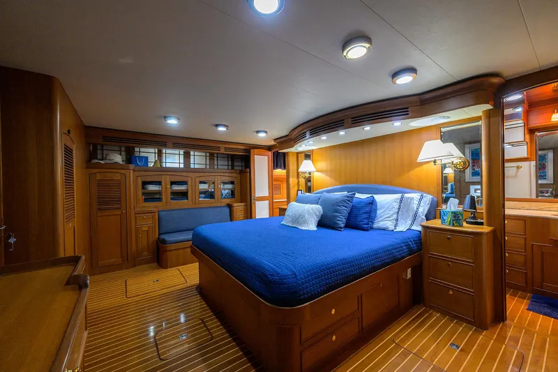 Bandol Yacht Photos Pics Luxurious cabin interior of 2006 Marlow 78E yacht with wooden furnishings and blue bedding.
