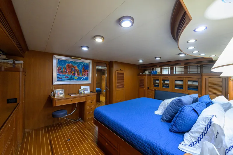 Bandol Yacht Photos Pics Luxurious Marlow 78E 2006 yacht bedroom with blue bedding and wooden decor.