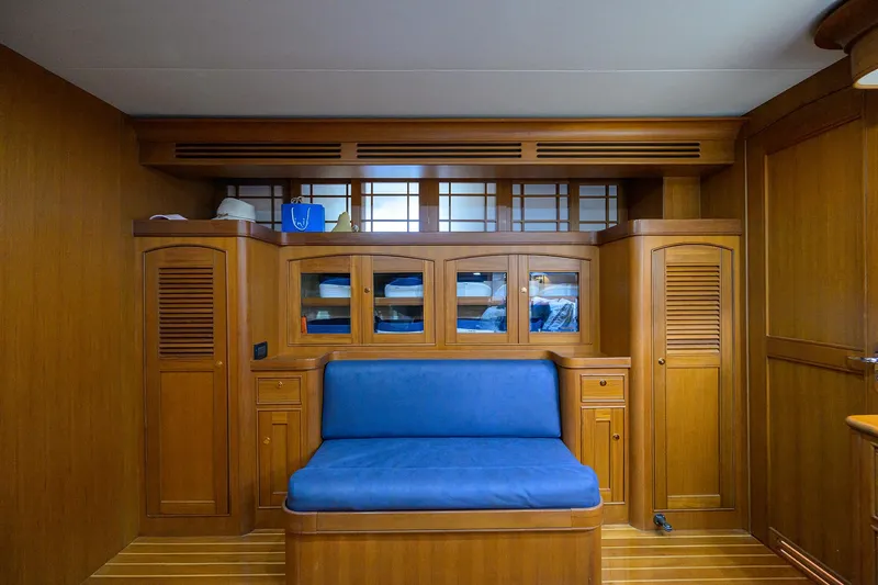 Bandol Yacht Photos Pics Luxurious wooden interior of 2006 Marlow 78E yacht with blue cushioned seating.