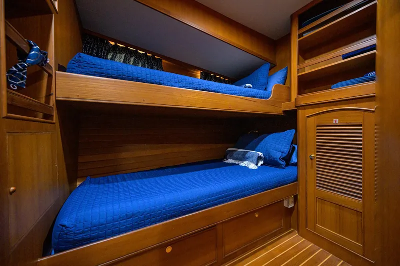Bandol Yacht Photos Pics Wooden bunk beds with blue bedding in a 2006 Marlow 78E yacht cabin.