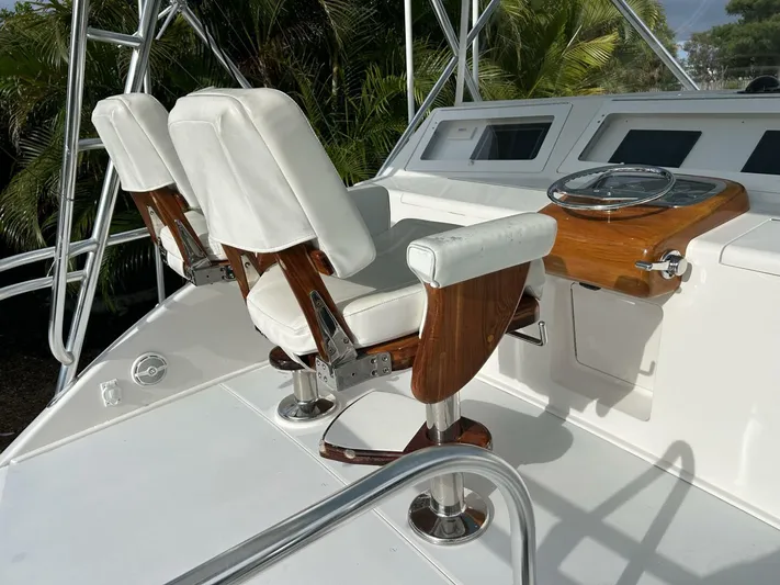 Rusty Yacht Photos Pics 2006 Viking 52 Convertible yacht helm with white leather seats and wooden accents.