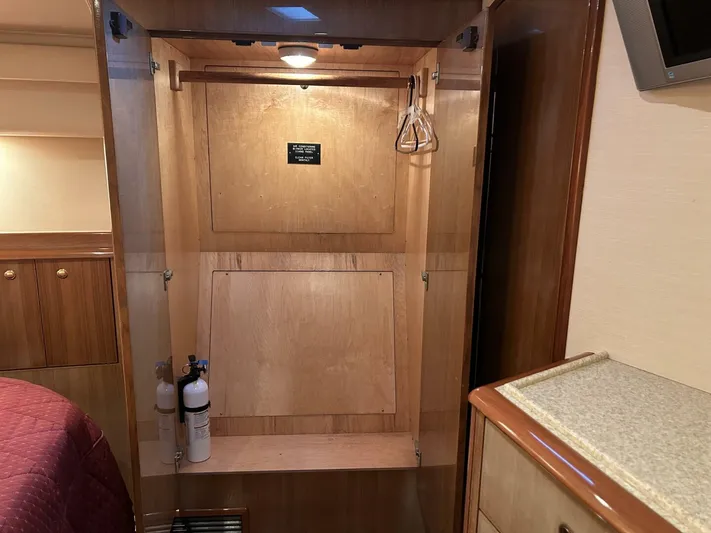 Rusty Yacht Photos Pics Interior of 2006 Viking 52 Convertible yacht showing a wooden closet with hangers and fire extinguishers.