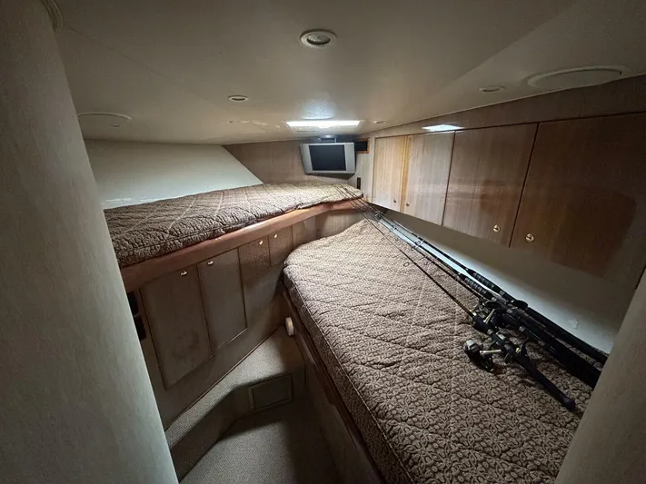 Rusty Yacht Photos Pics Interior cabin of 2006 Viking 52 Convertible yacht with twin beds and fishing rods.