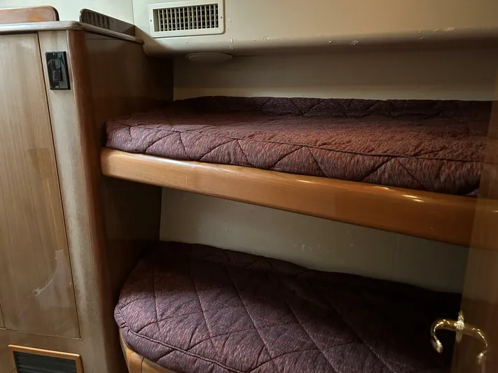 Rusty Yacht Photos Pics Bunk beds in a 2006 Viking 52 Convertible yacht cabin, featuring wooden frames and quilted bedding.