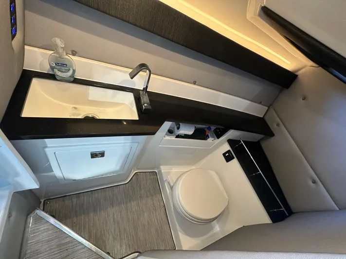  Yacht Photos Pics Modern bathroom interior in 2022 Cobalt R33 boat, featuring sink and toilet.