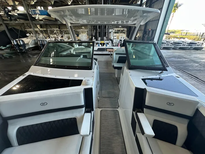  Yacht Photos Pics 2022 Cobalt R33 boat interior with sleek seating and modern design in a marina setting.
