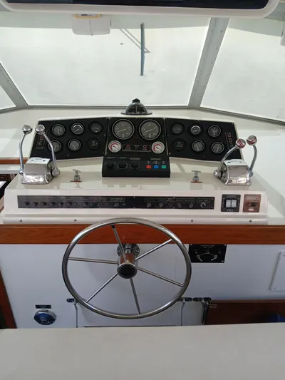  Yacht Photos Pics 1986 Bertram 46 Flybridge Motor Yacht helm with steering wheel and control panel.
