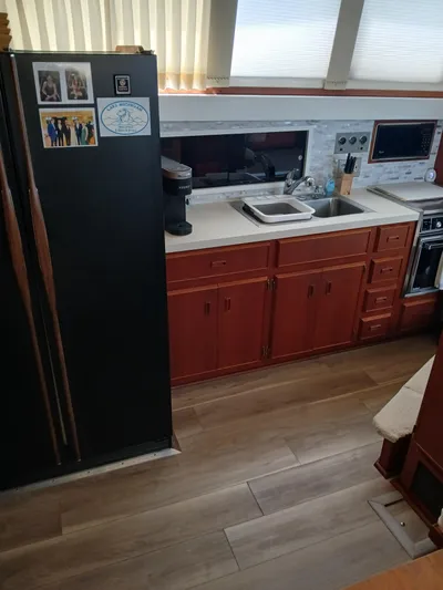  Yacht Photos Pics 1986 Bertram 46 Flybridge Motor Yacht kitchen with wooden cabinets and modern appliances.