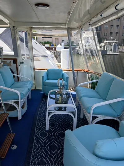  Yacht Photos Pics Interior of 1986 Bertram 46 Flybridge Motor Yacht with blue seating and glass table.