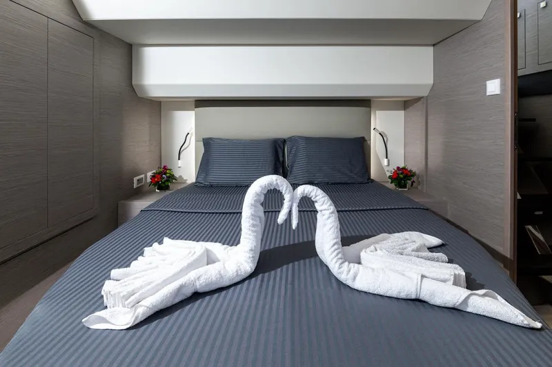  Yacht Photos Pics Luxurious bedroom in 2022 Fountaine Pajot MY6 yacht with elegant towel swans on bed.