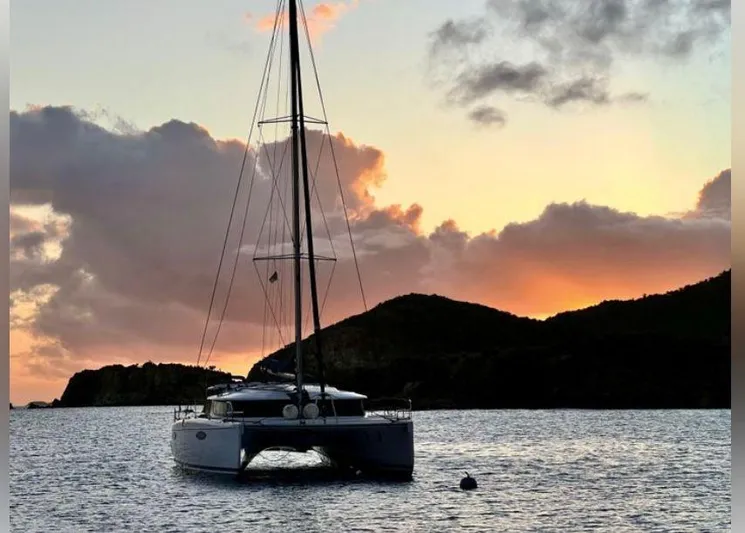 Red Yacht Photos Pics 2008 Fountaine Pajot Orana 44 catamaran at sunset, anchored in tranquil waters.