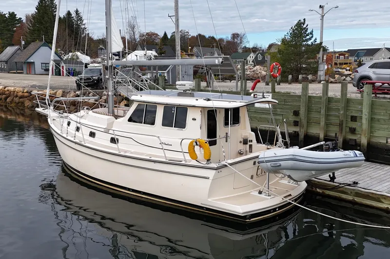  Yacht Photos Pics 2008 Island Packet SP Cruiser docked at a marina, featuring a dinghy and coastal backdrop.