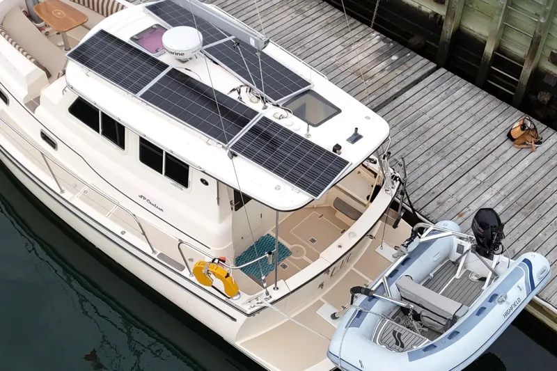  Yacht Photos Pics 2008 Island Packet SP Cruiser with solar panels and dinghy docked at a wooden pier.