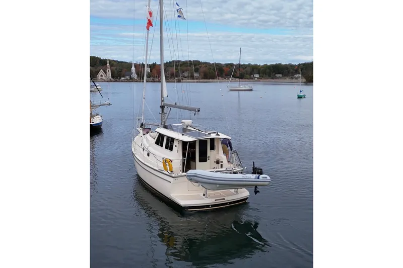  Yacht Photos Pics 2008 Island Packet SP Cruiser sailboat anchored in a serene harbor with scenic background.