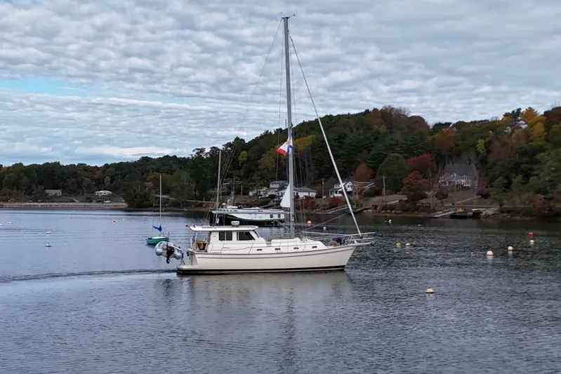  Yacht Photos Pics 2008 Island Packet SP Cruiser sailboat on a serene lake with autumn foliage.