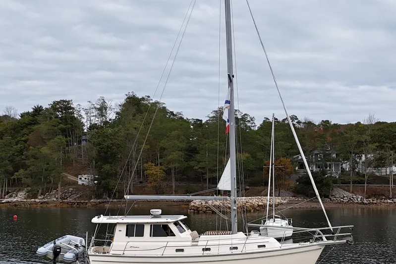  Yacht Photos Pics 2008 Island Packet SP Cruiser sailboat docked in a serene, wooded harbor.