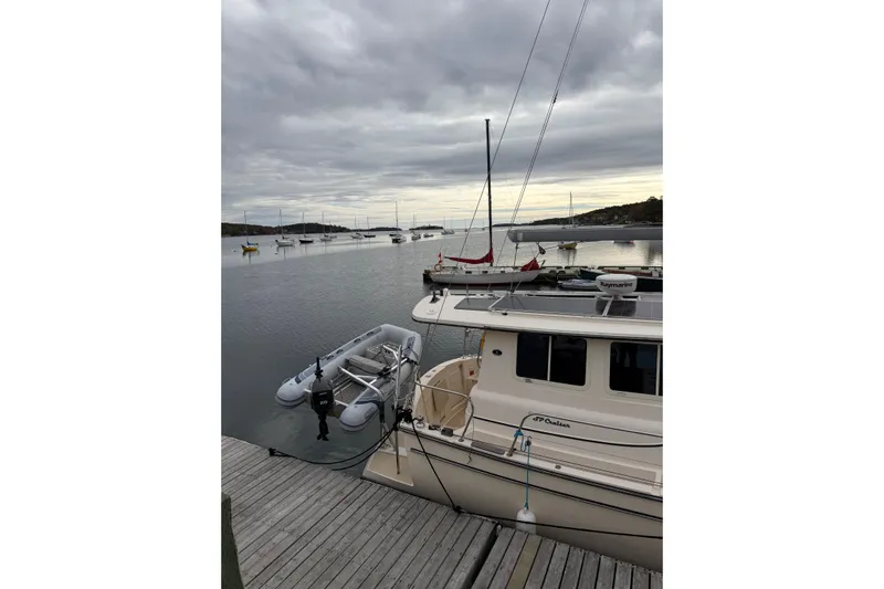  Yacht Photos Pics 2008 Island Packet SP Cruiser docked with inflatable boat, overcast sky, calm waters.