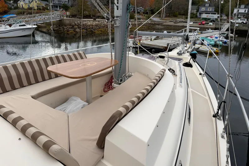  Yacht Photos Pics 2008 Island Packet SP Cruiser sailboat with striped seating and wooden table, docked in a marina.