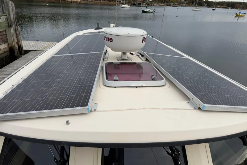  Yacht Photos Pics 2008 Island Packet SP Cruiser with solar panels on deck, docked by a serene lake.