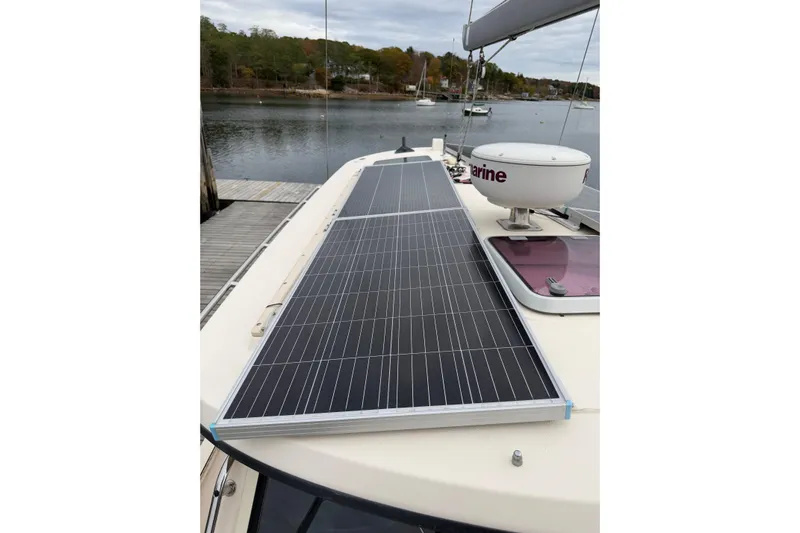 Yacht Photos Pics 2008 Island Packet SP Cruiser with solar panels on deck, docked by a serene lake.