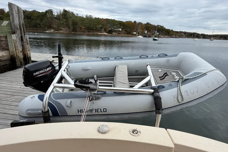  Yacht Photos Pics Inflatable boat with Mercury motor docked by a serene lakeside.