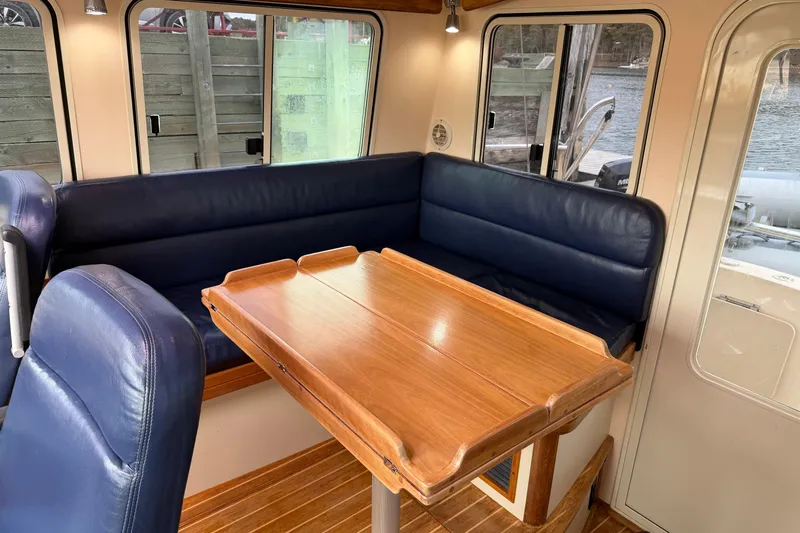 Yacht Photos Pics 2008 Island Packet SP Cruiser interior with blue seating and wooden table.