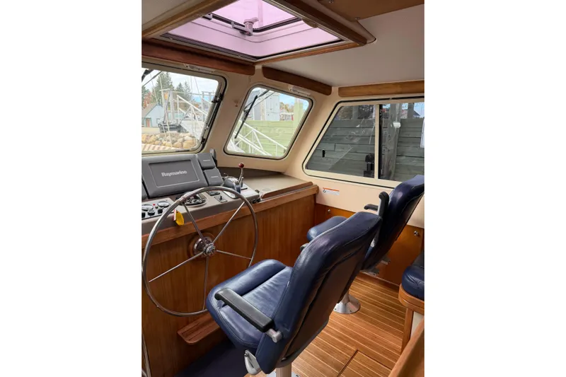  Yacht Photos Pics 2008 Island Packet SP Cruiser helm with steering wheel, navigation system, and blue seats.
