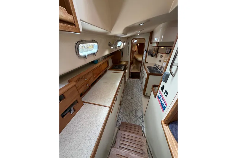  Yacht Photos Pics 2008 Island Packet SP Cruiser interior with wooden cabinetry and compact kitchen area.