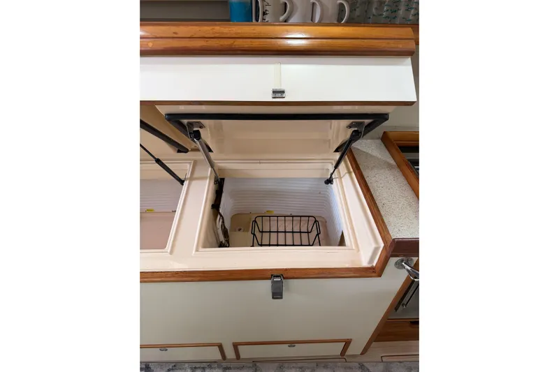  Yacht Photos Pics 2008 Island Packet SP Cruiser interior with open storage compartment and wooden trim.