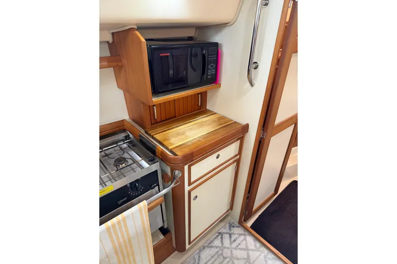  Yacht Photos Pics 2008 Island Packet SP Cruiser galley with microwave, stove, and wooden cabinetry.