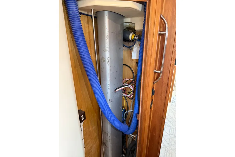  Yacht Photos Pics 2008 Island Packet SP Cruiser interior showing wiring and blue hose in a wooden compartment.