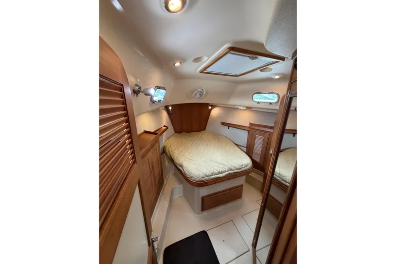  Yacht Photos Pics 2008 Island Packet SP Cruiser cabin with cozy bed and wooden interior.