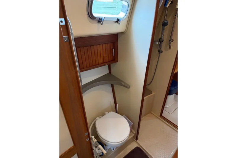  Yacht Photos Pics 2008 Island Packet SP Cruiser bathroom with toilet, shower, and wooden cabinetry.