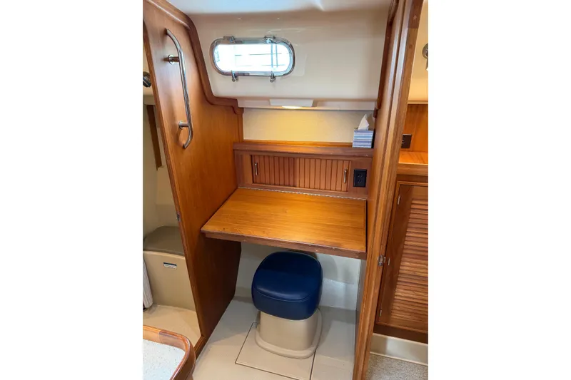  Yacht Photos Pics 2008 Island Packet SP Cruiser interior with wooden desk and blue cushioned stool.
