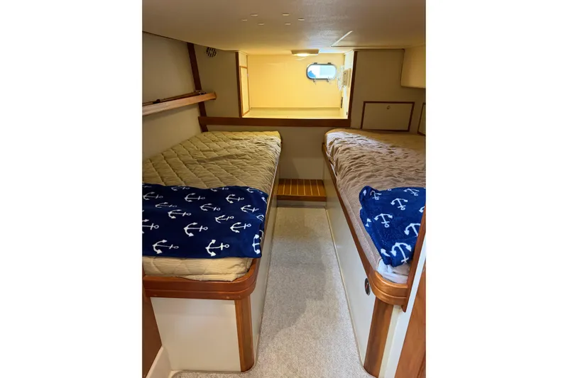  Yacht Photos Pics 2008 Island Packet SP Cruiser cabin with twin beds and nautical-themed blankets.