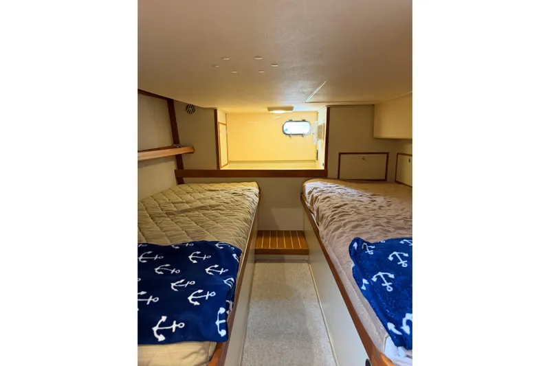  Yacht Photos Pics 2008 Island Packet SP Cruiser cabin with twin beds and nautical-themed blankets.